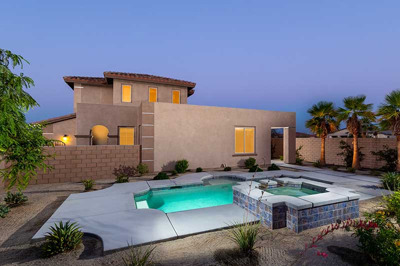 backyard with pool and spa at twilight.